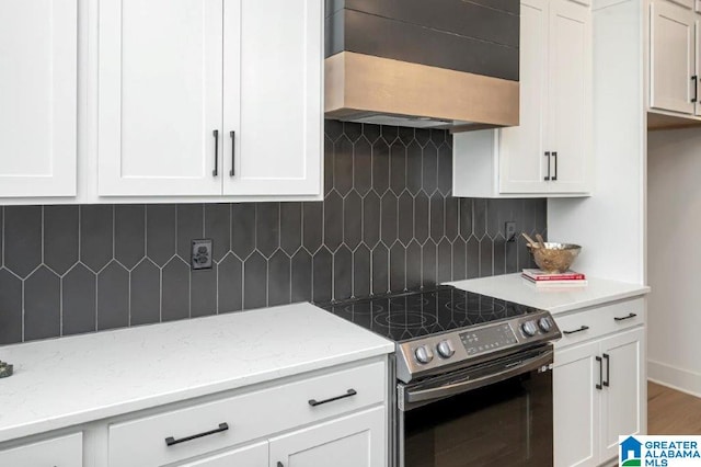 kitchen featuring white cabinets, range with electric stovetop, and tasteful backsplash