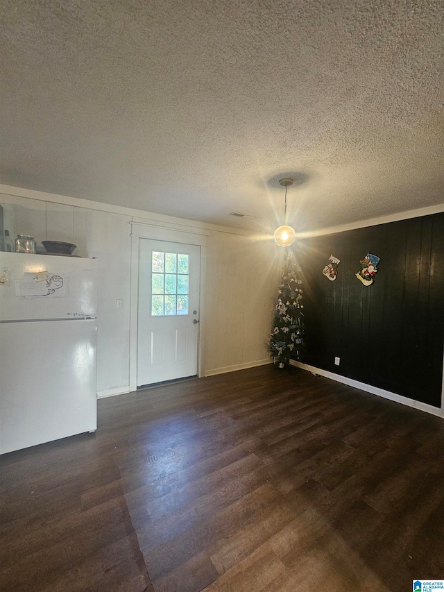 unfurnished living room with a textured ceiling and dark hardwood / wood-style flooring