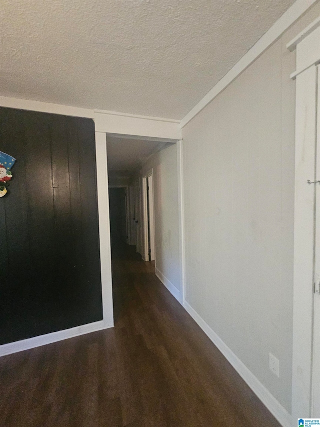 hallway featuring a textured ceiling and dark wood-type flooring