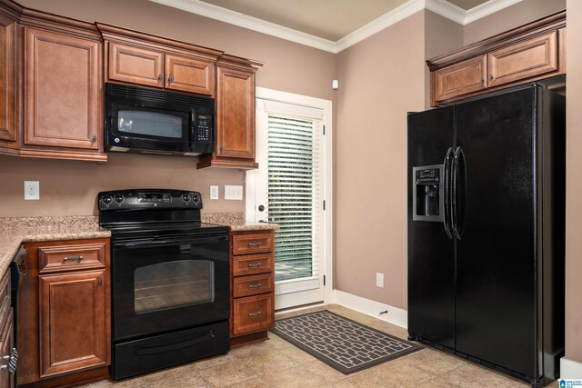 kitchen with black appliances, light tile patterned flooring, light stone countertops, and ornamental molding