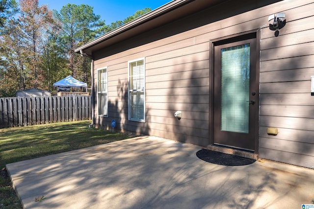 doorway to property with a yard and a patio