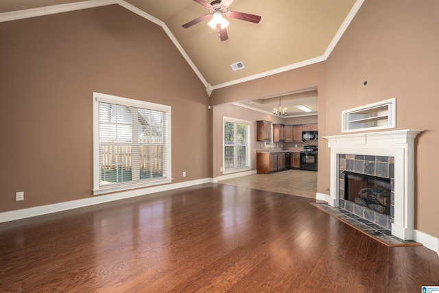 unfurnished living room with crown molding, a tile fireplace, dark wood-type flooring, and high vaulted ceiling