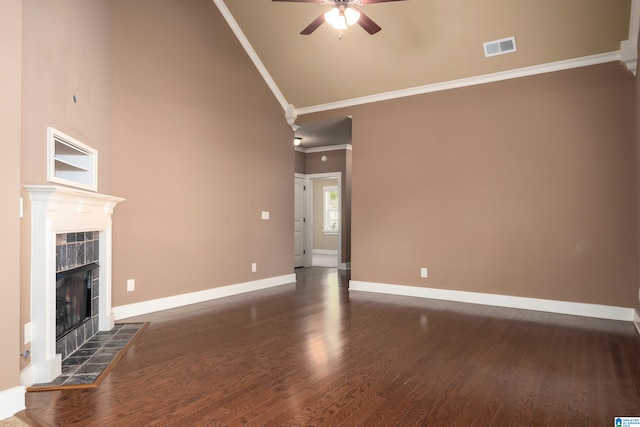 unfurnished living room with ornamental molding, ceiling fan, dark wood-type flooring, a tile fireplace, and high vaulted ceiling