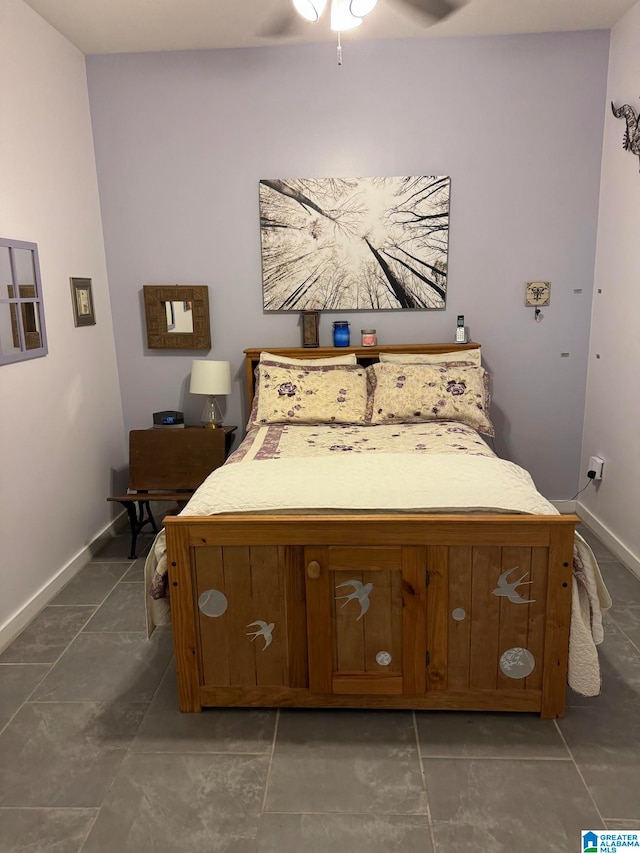 bedroom with dark tile patterned floors and ceiling fan