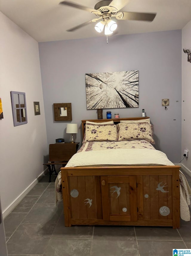 bedroom with ceiling fan and dark tile patterned floors