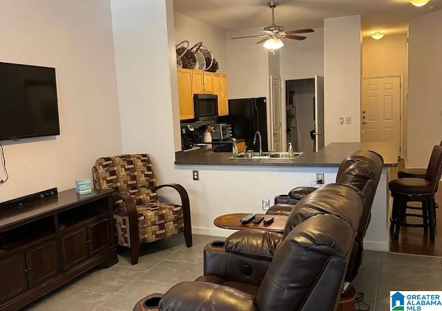 living room with light tile patterned floors, ceiling fan, and sink