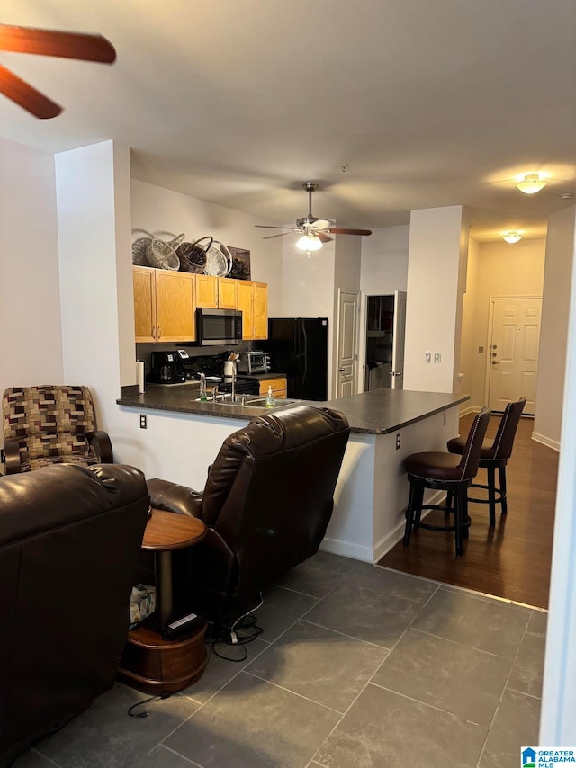 living room featuring ceiling fan and dark tile patterned flooring