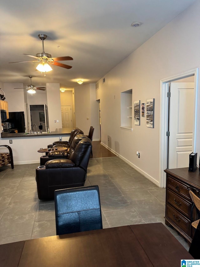 living room with ceiling fan, sink, and tile patterned flooring