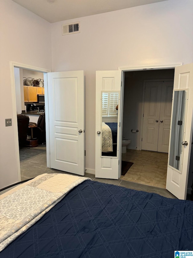 unfurnished bedroom featuring tile patterned flooring, french doors, and a closet