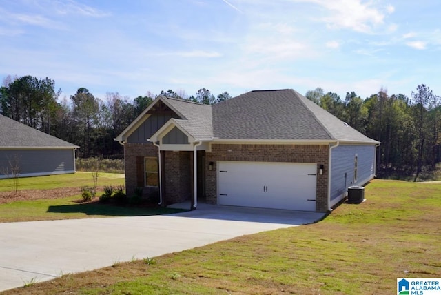 view of front of property featuring a front yard, a garage, and central AC unit