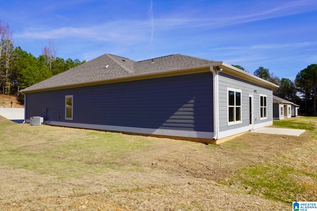 view of property exterior with a patio area, a yard, and central air condition unit