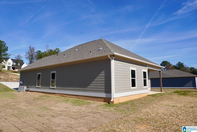 view of side of home with a yard and central air condition unit