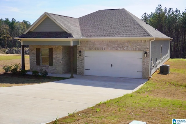 view of front facade featuring a front lawn, cooling unit, and a garage