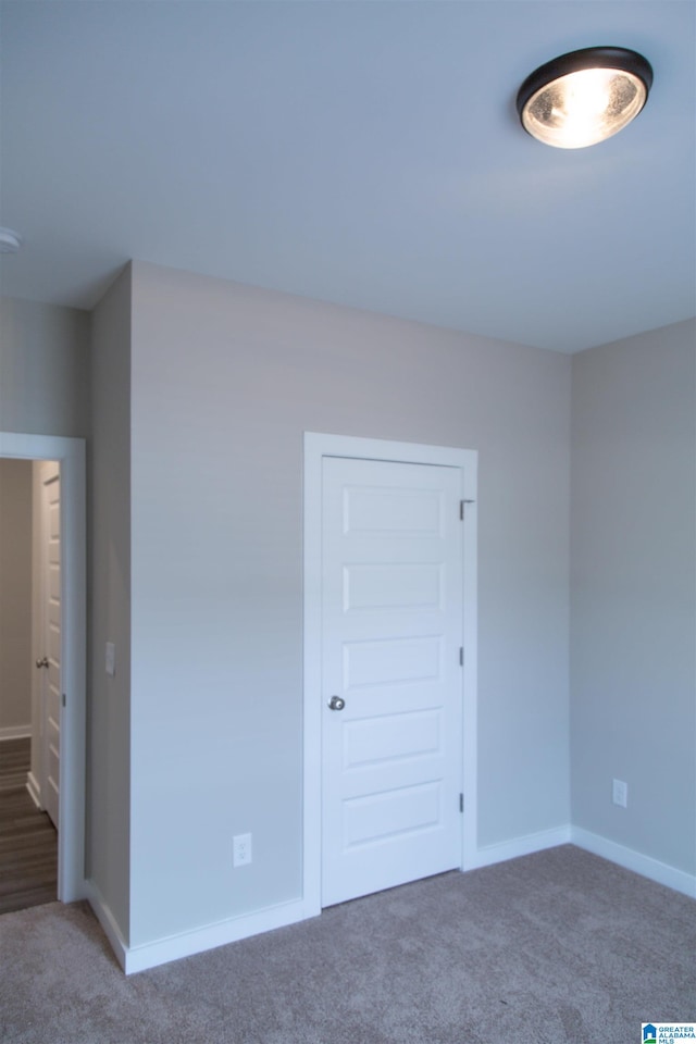 spare room featuring dark colored carpet