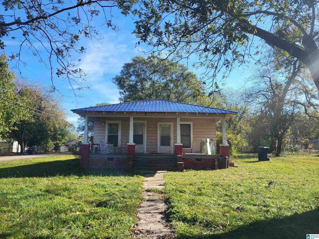 bungalow featuring covered porch and a front lawn