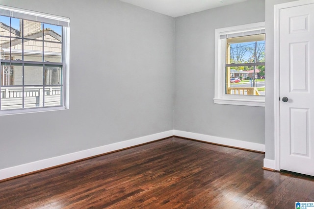 unfurnished room featuring a healthy amount of sunlight and dark hardwood / wood-style floors