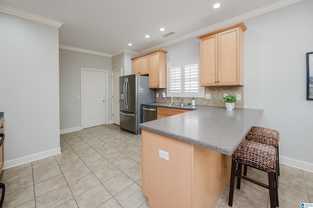 kitchen featuring kitchen peninsula, a kitchen bar, backsplash, crown molding, and sink