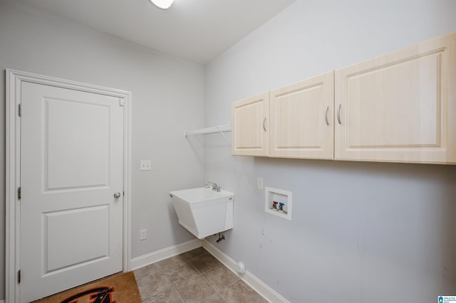 washroom featuring cabinets, hookup for a washing machine, light tile patterned floors, and sink