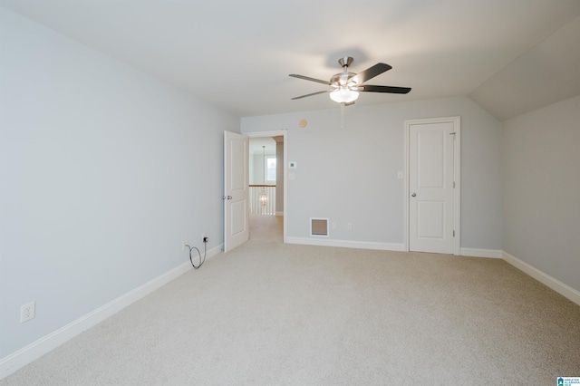 interior space featuring ceiling fan, light carpet, and vaulted ceiling