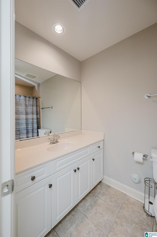 bathroom featuring tile patterned flooring, vanity, and toilet