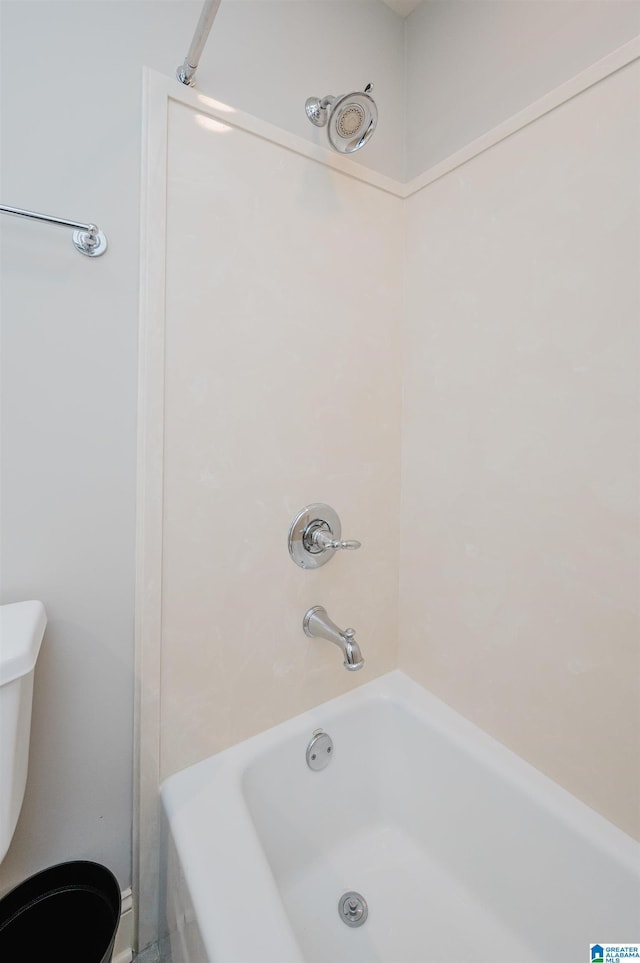 bathroom with bathing tub / shower combination and toilet