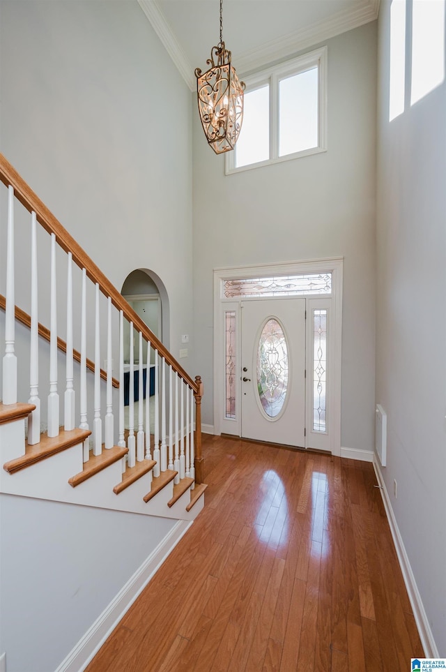 foyer entrance featuring a wealth of natural light, hardwood / wood-style floors, and a high ceiling