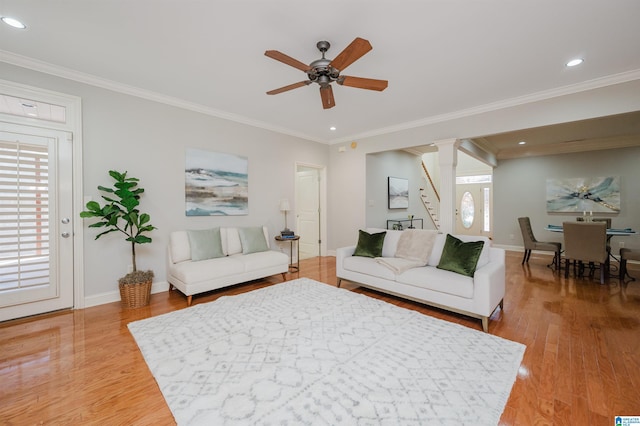 living room featuring ceiling fan, hardwood / wood-style floors, and ornamental molding