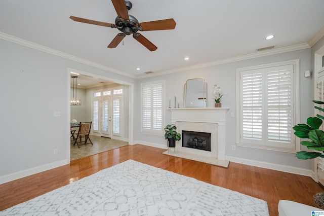 living room featuring ceiling fan, light hardwood / wood-style floors, crown molding, and french doors