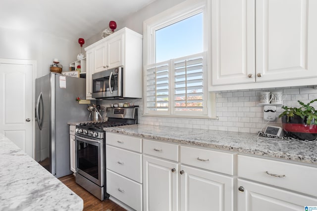 kitchen featuring white cabinets, stainless steel appliances, and plenty of natural light