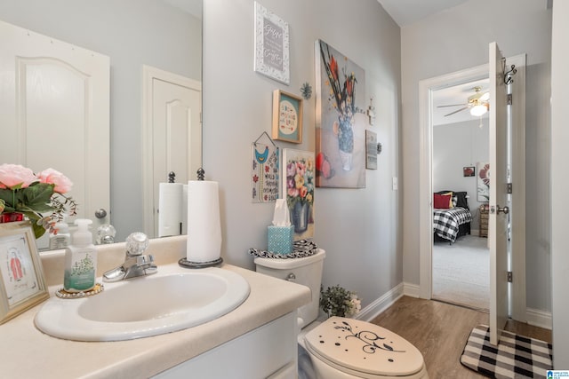 bathroom featuring hardwood / wood-style floors, vanity, ceiling fan, and toilet