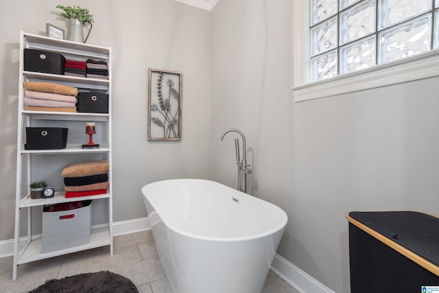 bathroom with tile patterned flooring, a tub to relax in, and ornamental molding