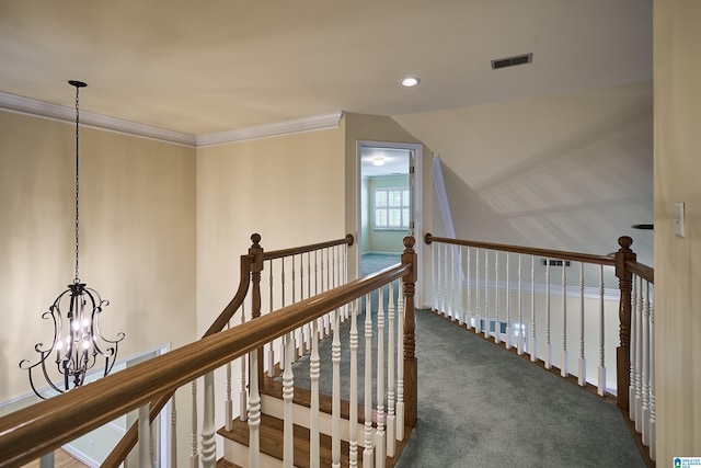 hallway with dark carpet, a notable chandelier, and crown molding