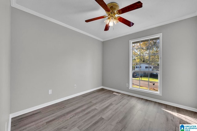 spare room featuring light wood-type flooring, ceiling fan, and crown molding