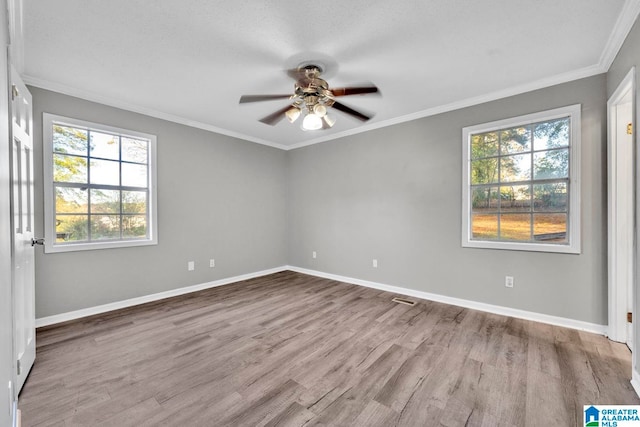 unfurnished room with ceiling fan, plenty of natural light, ornamental molding, and light hardwood / wood-style flooring