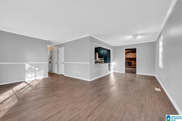 unfurnished living room featuring a fireplace, dark hardwood / wood-style floors, and crown molding