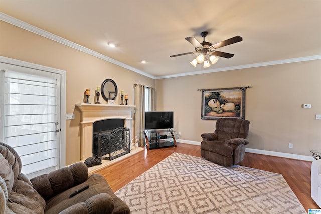 living room with hardwood / wood-style floors, crown molding, and ceiling fan