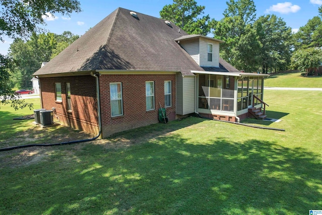 back of house featuring a sunroom, central AC, and a lawn