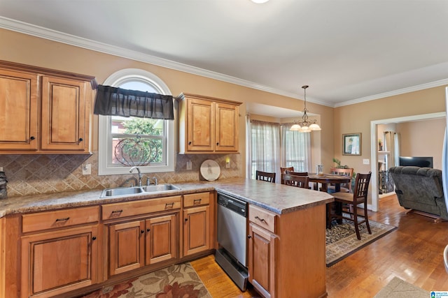 kitchen featuring stainless steel dishwasher, kitchen peninsula, sink, and backsplash