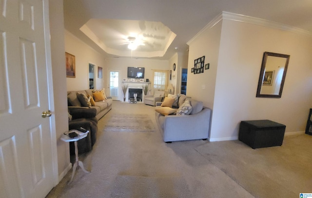 living room with carpet flooring, a raised ceiling, crown molding, and ceiling fan