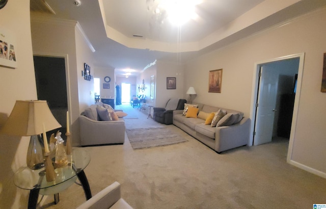 living room featuring carpet flooring, a raised ceiling, and crown molding