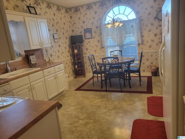 dining area with sink and an inviting chandelier