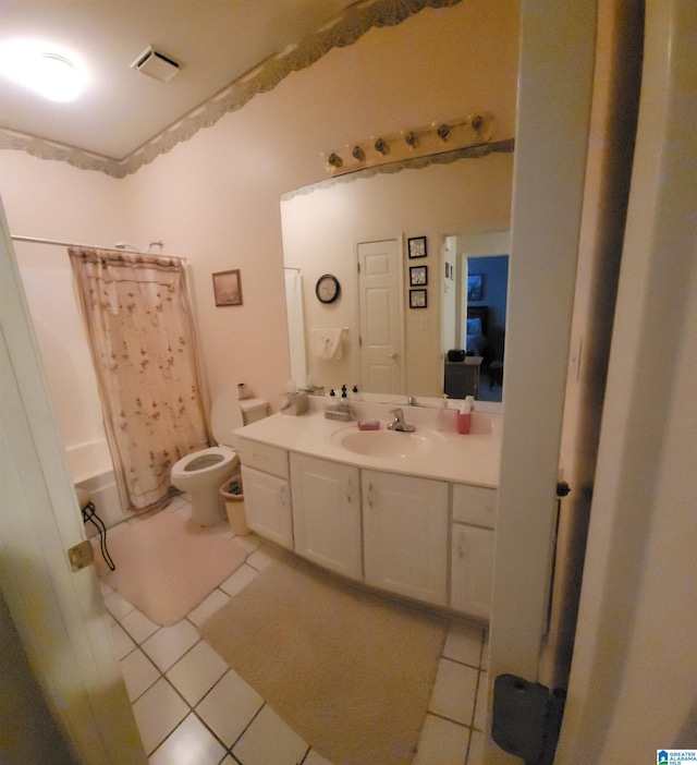 bathroom featuring tile patterned flooring, a shower with curtain, vanity, and toilet