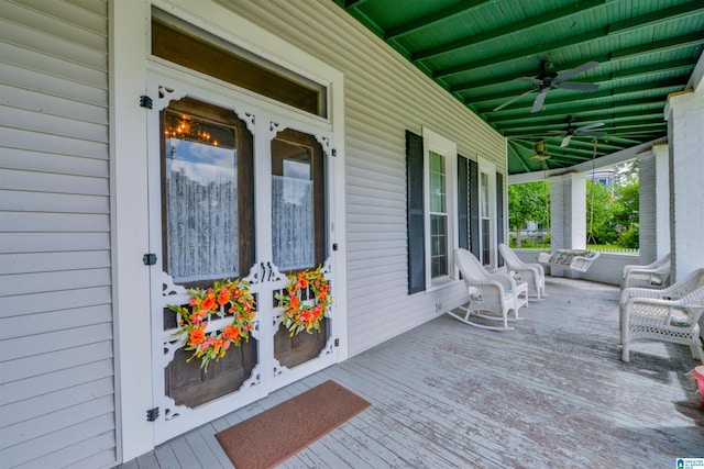 wooden terrace featuring covered porch and ceiling fan