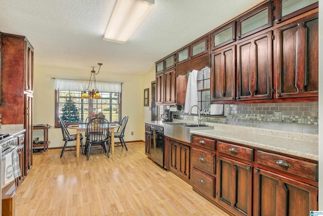 kitchen featuring sink, dishwasher, tasteful backsplash, decorative light fixtures, and light wood-type flooring