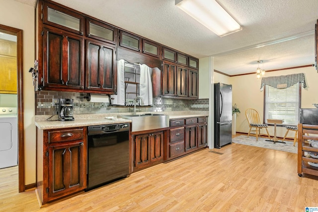 kitchen featuring a textured ceiling, light hardwood / wood-style floors, ornamental molding, and black appliances