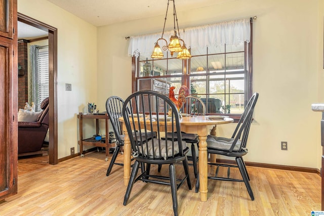 dining space with a notable chandelier and light wood-type flooring