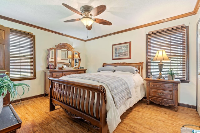 bedroom with ceiling fan, crown molding, light hardwood / wood-style floors, and a textured ceiling