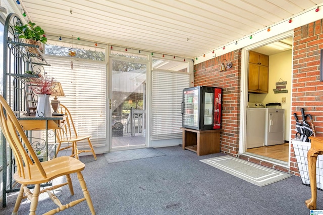 unfurnished sunroom with separate washer and dryer, wooden ceiling, and track lighting