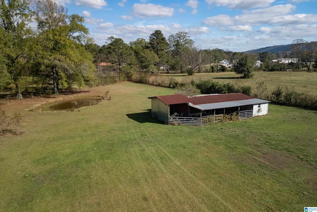 view of yard featuring a mountain view, a rural view, and an outdoor structure