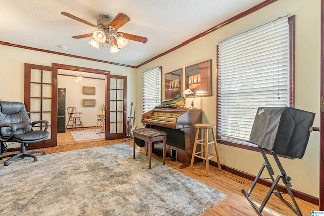 office area with french doors, ceiling fan, ornamental molding, a textured ceiling, and light hardwood / wood-style floors